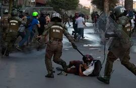Carabineros de Chile reprimen a un manifestante durante una protesta ayer, 27 de noviembre, en Santiago.
