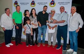 Luis María Maluff (d) recibe el trofeo en el premio "Homenaje a don Emhil Morel" por parte de familiares del extinto socio del Jockey Club del Paraguay, luego del triunfo de Perfume de Rosal.