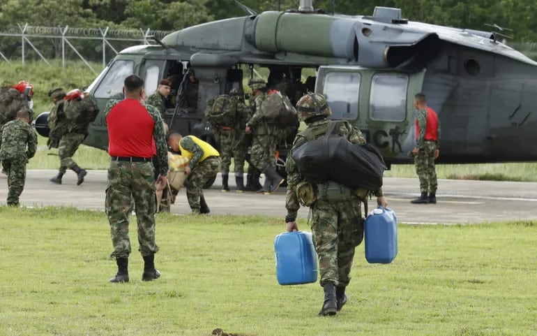 Soldados abordan un helicóptero que se dirige a la zona de búsqueda de los menores perdidos desde hace 20 días después de un accidente aéreo en el sur de Colombia.