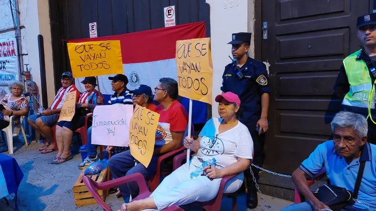 Jubilados están encadenados frente a la sede de la Caja Municipal para exigir la intervención de la institución.