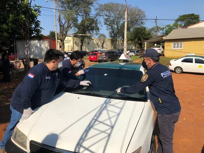 Agentes del Departamento de Criminalística de la Policía Nacional verifican el automóvil.