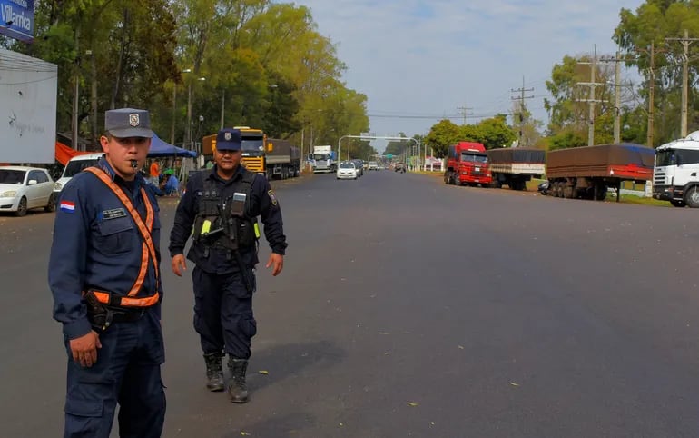 Dos agentes policiales dirigiendo el tránsito vehícular en el cruce Villarrica-Paraguarí sobre la Ruta PY08, este martes.