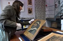 La historiadora Paula Etkin revisa un cuadro en el Museo de Arte Popular José Hernández, en Buenos Aires (Argentina).