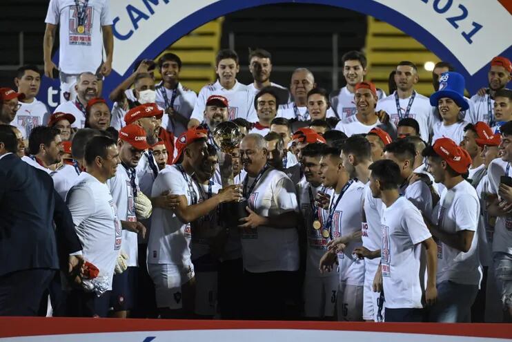 Francisco Arce (d), entrenador de Cerro Porteño, sostiene el trofeo de campeón.