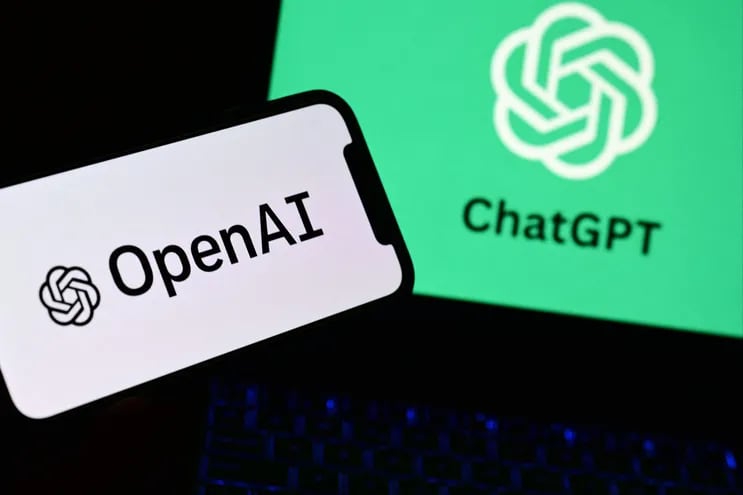 Un teléfono inteligente y una computadora portátil que muestran los logotipos del laboratorio de investigación de inteligencia artificial OpenAI y del robot ChatGPT.