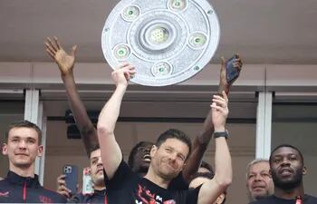 Leverkusen (Germany), 14/04/2024.- Leverkusen's head coach Xabi Alonso lifts a mock Bundesliga Meisterschale trophy, celebrating the German Bundesliga championship with his team after the German Bundesliga soccer match between Bayer 04 Leverkusen and SV Werder Bremen in Leverkusen, Germany, 14 April 2024. (Alemania) EFE/EPA/CHRISTOPHER NEUNDORF CONDITIONS - ATTENTION: The DFL regulations prohibit any use of photographs as image sequences and/or quasi-video.
