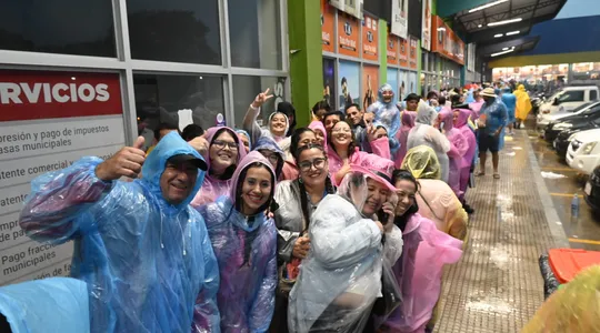 Fans de Karol G refugiándose de la lluvia.