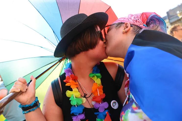 Participantes de una  marcha por el orgullo gay se besan durante una manifestación.