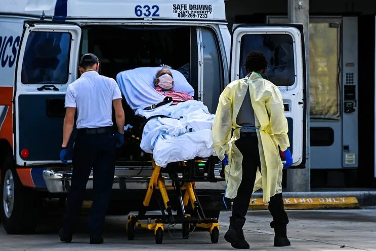 Paramédicos transfieren a un paciente con coronavirus en una ambulancia en el Hospital de Coral Gables, Florida.
