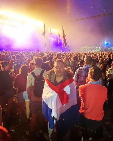 Envuelto en una bandera paraguaya, el embajador del Reino Unido en paraguay, Ramin Navai, entre el público asistente al festival de Glastonbury, en Somerset, Inglaterra.