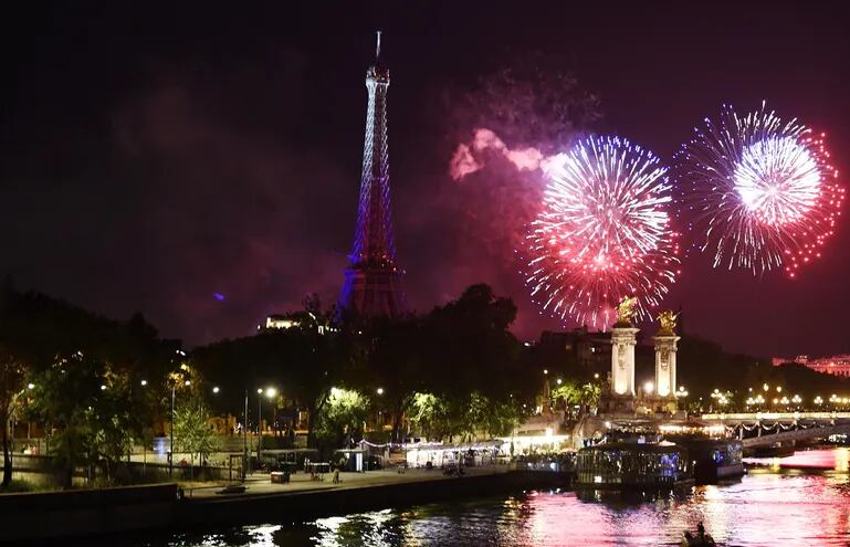 Los fuegos artificiales iluminan el cielo cerca de la Torre Eiffel, en París, como parte de las celebraciones  por el aniversario del asalto de la fortaleza de la Bastilla en 1789.