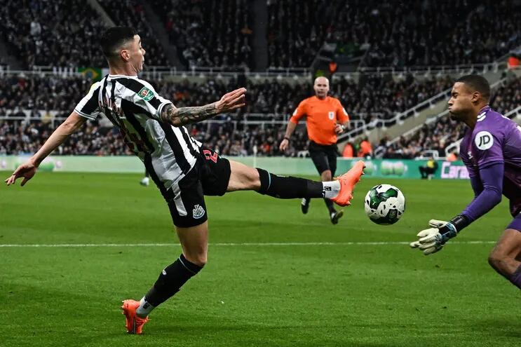 Miguel Almirón procura puntear el balón ante la salida del arquero Gavin Bazunu, del Southampton, durante el partido que Newcastle ganó ayer en casa 2-1.