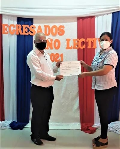 Don Carlos Ayala recibe su título de manos de su directora Lic. Marlene Alcaraz