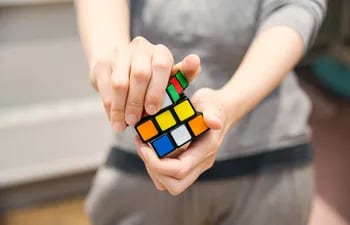 Fotografía de referencia: una persona girando cubo de Rubik buscando igualar sus colores.