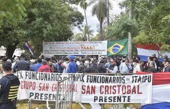 Ex obreros de Itaipu se autoconvocan Frente al Congreso para seguir la sesión de Diputados.