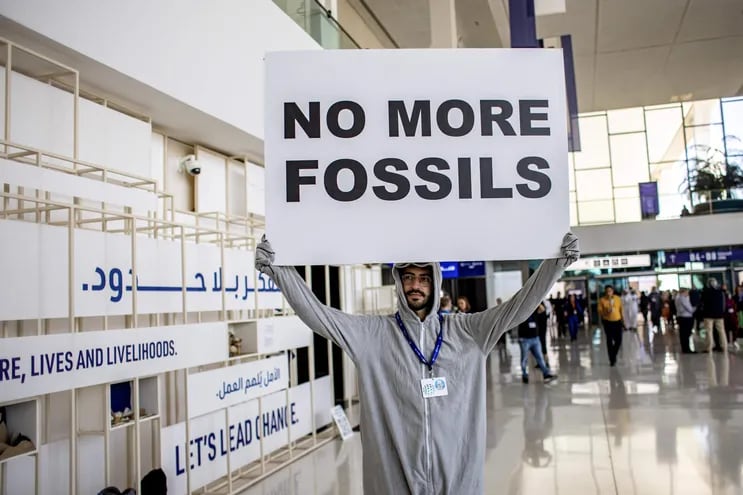 Un activista con un cartel pidiendo el fin de los combustibles fósiles protesta en Dubái, el pasado miércoles.