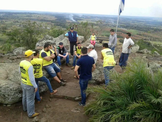 Integrantes de la Asociación de Jóvenes por Capiibary reunidos sobre el Cerro dos de Oro proyectando los trabajos en el lugar.