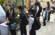 Niños y niñas forman filas para lavarse las manos al llegar a la Escuela San Francisco, de Asunción, para el inicio del año lectivo 2023.