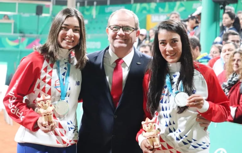 Montserrat González (i), y Verónica Cepede, quedaron en el segundo escalafón del podio en dobles de tenis. Aquí compartiendo su alegría con Camilo Pérez López Moreira y exhibiendo sus preseas de plata.