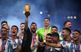 Lionel Messi levanta el trofeo de la Copa del Mundo rodeado de sus compañeros.