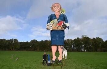 La artista Andrea Deans posa junto a su efigie de la ex primera ministra británica Liz Truss en su presentación en Edenbridge, Gran Bretaña.