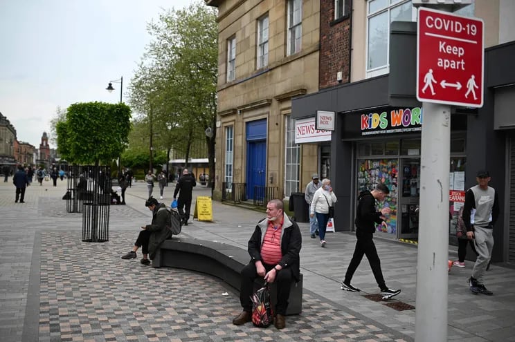 Un letrero pide a los miembros del público que se adhieran a las pautas actuales de distanciamiento social, ya que una variante de preocupación de Covid-19 está afectando a la comunidad en Bolton, noroeste de Inglaterra.