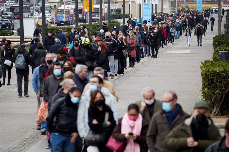 Cientos de personas esperan para vacunarse en el centro de vacunación de La Fira de Barcelona.