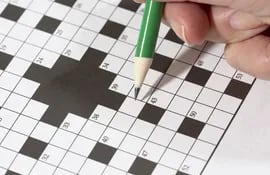 Una persona completa un cucrigrama con un lápiz verde