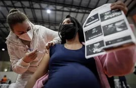 Una mujer embarazada recibe una dosis de la vacuna Moderna, hoy en la sede de la Secretaría Nacional de Deportes de Asunción.