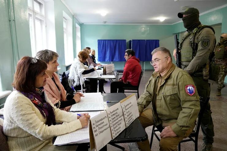 El líder prorruso Konstantin Ivashchenko (3ro. de la der) visita en Mariupol un local de votación para la anexión de la región separatista a Rusia. (AFP)