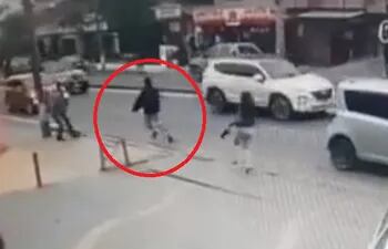 En la imagen se ve al asaltante, dentro del círculo rojo, huyendo de su víctima tras bajarse del bus.