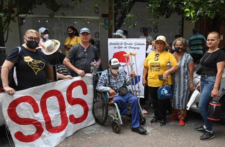El grupo de docentes jubilados, junto con un agente policial jubilado en silla de ruedas, que se manifestó frente a la Fiscalía General.