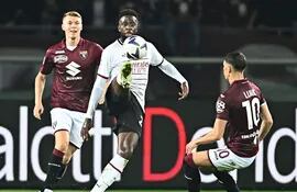 Divock Origi, delantero belga del AC Milan, intenta dominar el balón ante la presencia de dos jugadores del Torino.