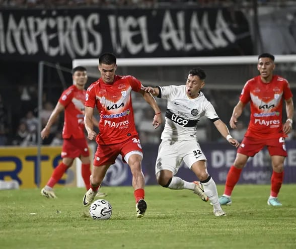 Carlos Alberto Arrúa, un talentoso puesto de volante central, intenta arrebatarle el balón a Luis Martínez Soto.