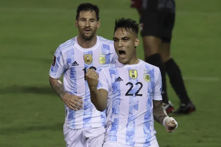 Lautaro Martínez celebra con los puños cerrados su gol y Lionel Messi se acerca para sumarse al festejo. Argentina goleó y Messi recibió una patada violenta que pudo haberlo quebrado.