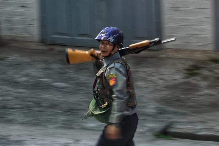 Un miembro de las fuerzas de seguridad birmanas portando una escopeta en el sitio de uno de los enfrentamientos entre manifestantes y las autoridades.