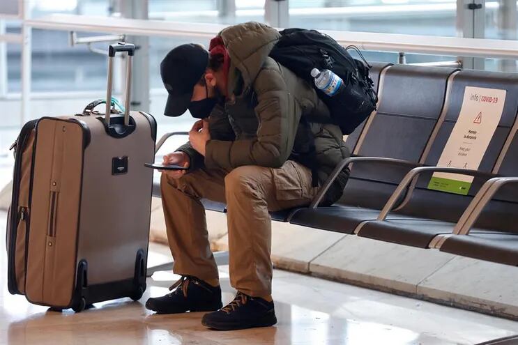 Un viajero revisa su teléfono en el aeropuerto Adolfo Suárez Madrid-Barajas, en Madrid.