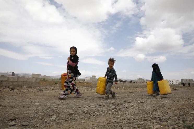 Niños llevan bidones de agua en las afueras de Saná, Yemen.