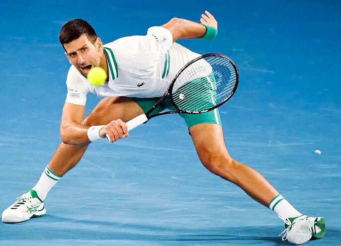 Novak Djokovic, de Serbia, en acción durante la cuarta ronda de individuales masculinos contra Milos Raonic, de Canadá, en torneo de tenis del Abierto de Australia en Melbourne Park. (EFE)