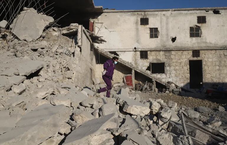 Un hombre camina entre los escombros de un edificio destruido por ataques aéreos rusos en las afueras de la ciudad de Idlib, Siria.