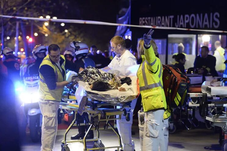 En esta foto de noviembre de 2015, un grupo de rescatistas evacua a una persona herida cerca del Bataclan, en París. Los responsables, incluido Salah Abdeslam, serán sometidos a juicio. -