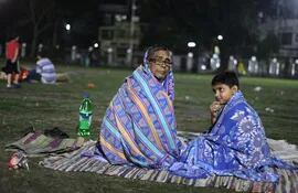 un-hombre-y-su-hijo-desplazados-por-el-terremoto-de-nepal-se-cubren-con-mantas-mientras-intentan-descansar-en-un-campo-de-futbol--214935000000-1322273.JPG