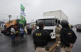 Miembros de la policía custodian a grupos de camioneros que bloquean carreteras, hoy en Río de Janeiro (Brasil). (EFE)