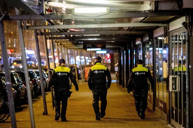Agentes de la policía holandesa patrullan en las calles de Rotterdam Sur, en Rotterdam, el 27 de enero de 2021 a raíz de las manifestaciones que brillaron en la ciudad y más en gran parte en el país tras la adopción de nuevas reglas para luchar contra la propagación del Covid- 19.