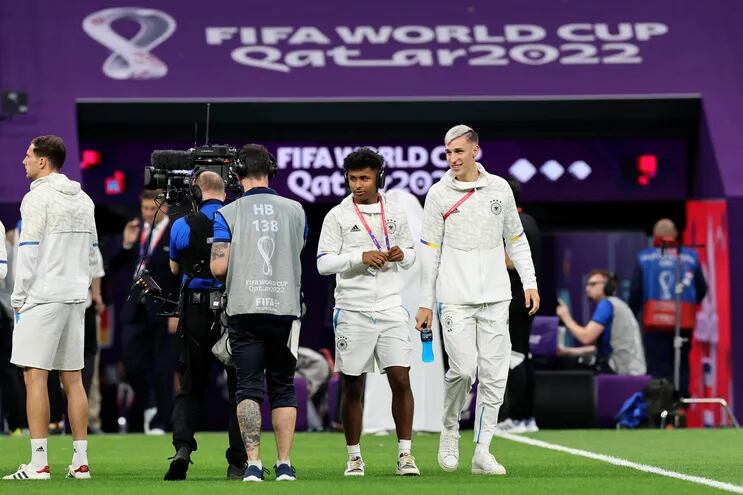 El delantero alemán #24 Karim Adeyemi (2ndR) y el defensor alemán #23 Nico Schlotterbeck caminan en la cancha antes del partido de fútbol del Grupo E de la Copa Mundial Qatar 2022 entre Costa Rica y Alemania en el Estadio Al-Bayt en Al Khor, al norte de Doha el 1 de diciembre de 2022.