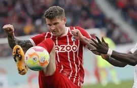 Lukas Kuebler (i), del Friburgo, rechaza el balón ante la presencia de Alphonso Davies, del Bayern Munich.