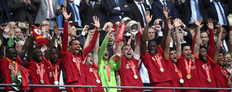 Jordan Henderson, capitán del Liverpool, levanta el trofeo de la FA Cup rodeado de sus compañeros.