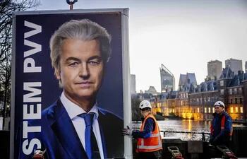 Obreros retiran un cartel del líder ultraderechista neerlandés Geert Wilders en La Haya, Países Bajos, este jueves.