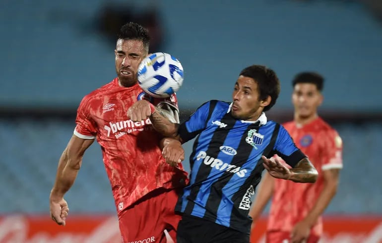 El paraguayo Gabriel Ávalos, delantero de Argentinos Juniors, cabecea el balón superando en el salto a Renzo Machado, del equipo de Liverpool.