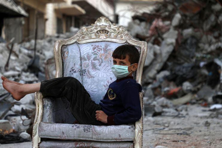 Un niño en un asiento en medio de una calle destrozada por ataques aéreos del régimen sirio en el poblado de Ariha, en la provincia de Idlib.